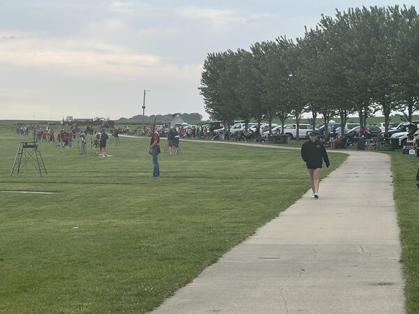 Midmorning on the grounds. Athletes on the line, families along the walk.